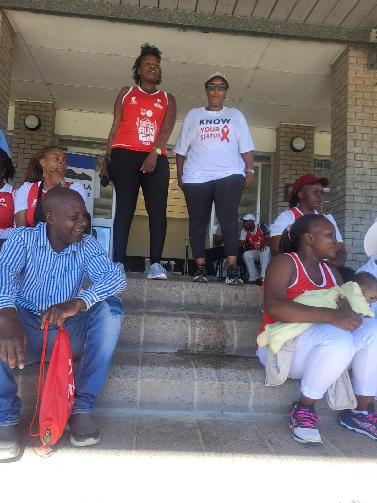 Foundation team members speaking to a community gathering on the steps of a community building