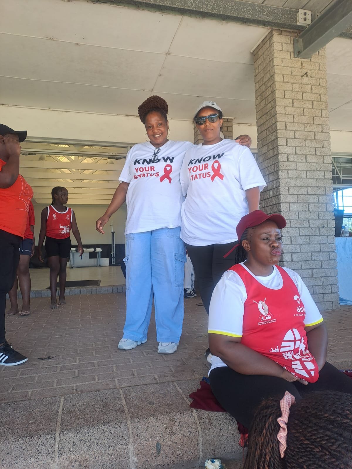 Two volunteers standing side by side in 'Know Your Status' campaign t-shirts