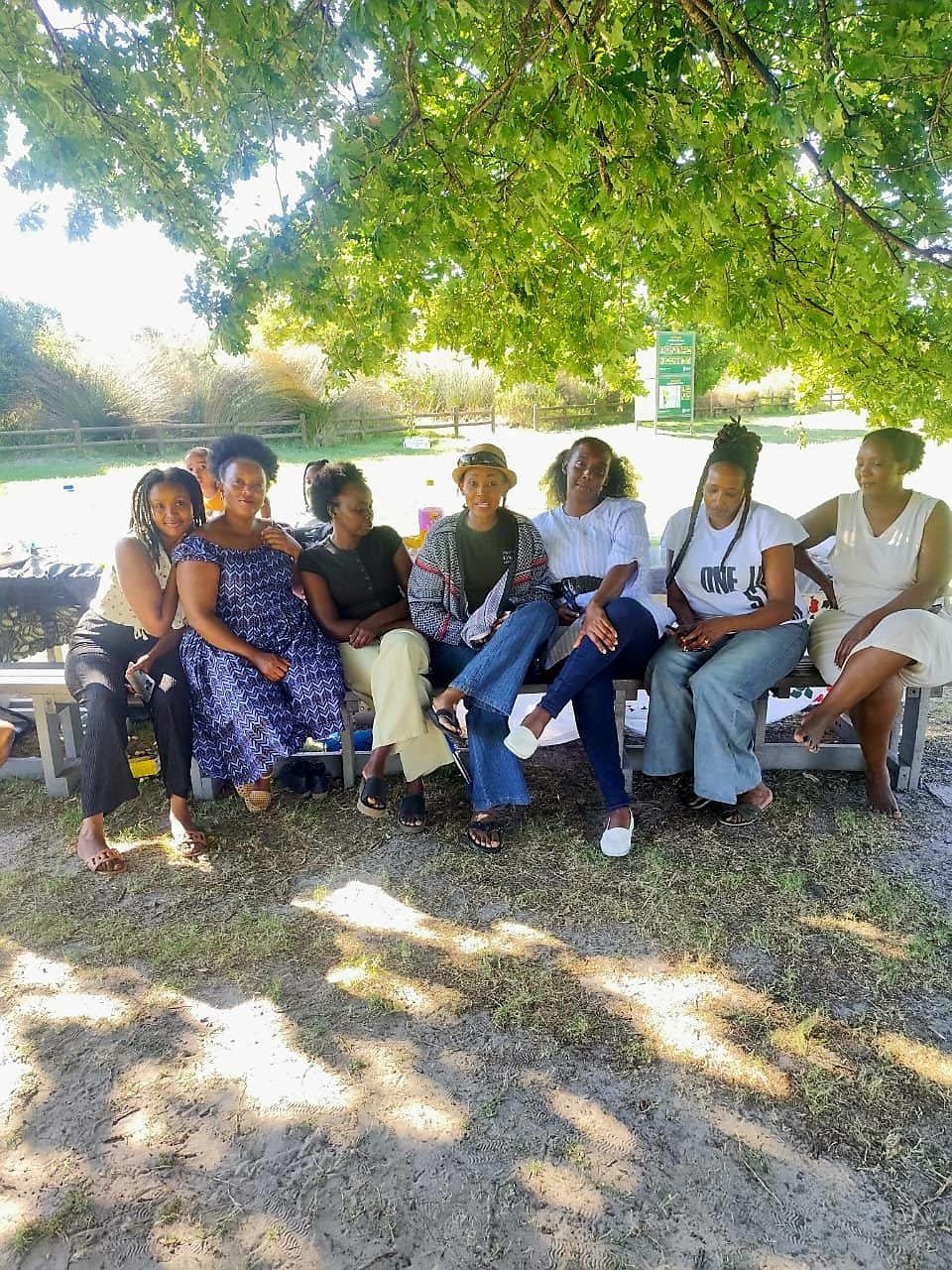 Group of Community Care Foundation team members and supporters gathered under a tree
